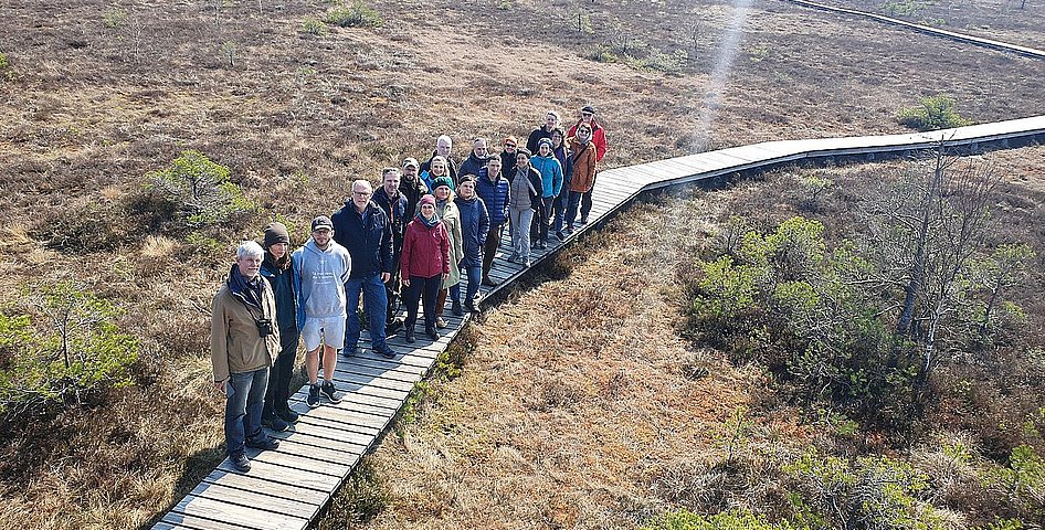 Gruppe von Menschen auf einem Steg im Moor aus der Vogelperspektive